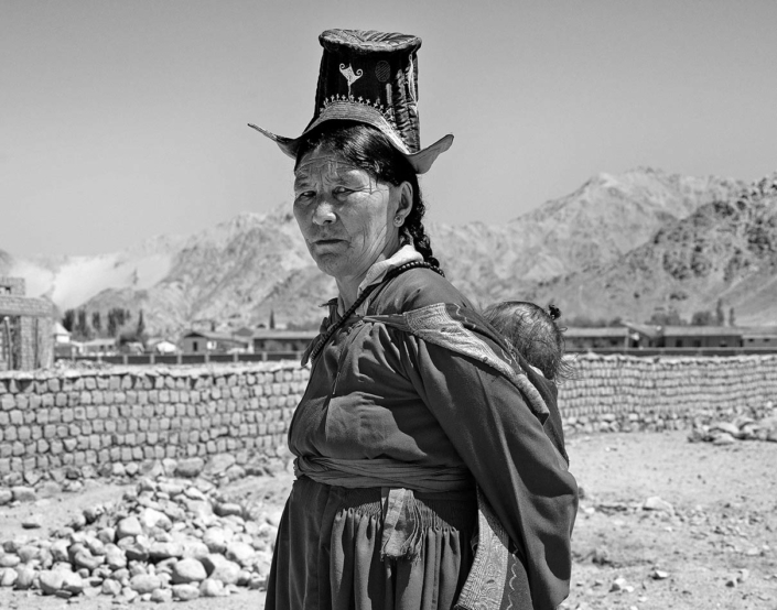 Woman in traditional dress and her baby near Thikse Gompa Ladakh India